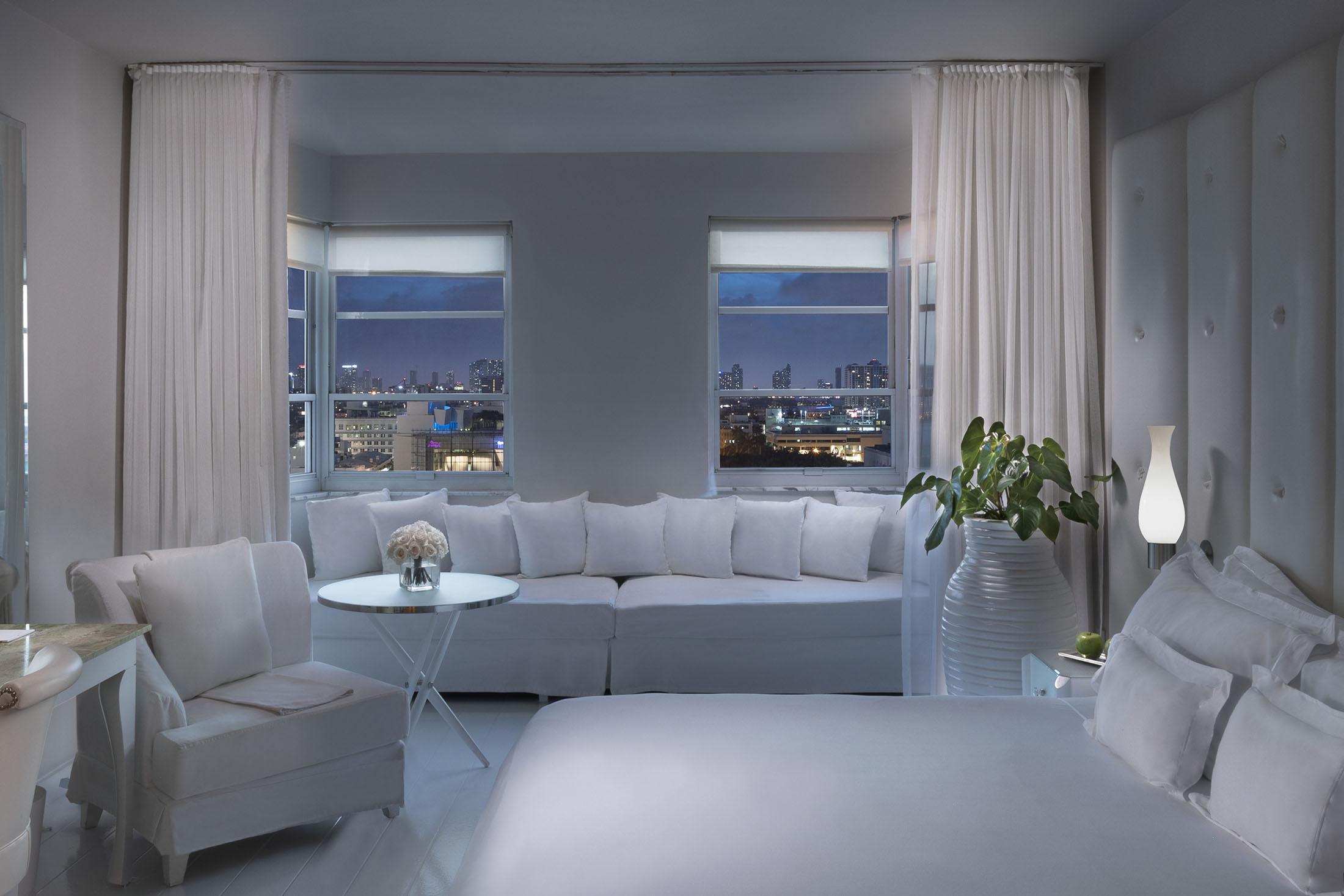 白色的床和白色的壁龛在窗前，享有城市景观